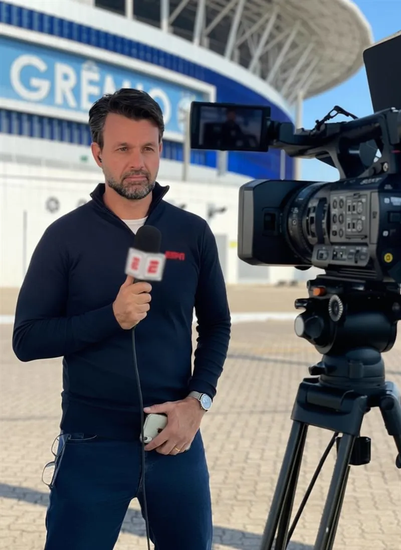 Gustavo Berton com o microfone da ESPN em frente à Arena do Grêmio